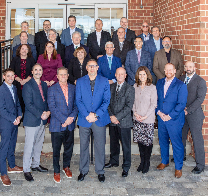 Group of Brown Plus team members in front of a brick building