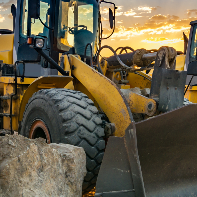 Two construction vehicles moving rock and gravel